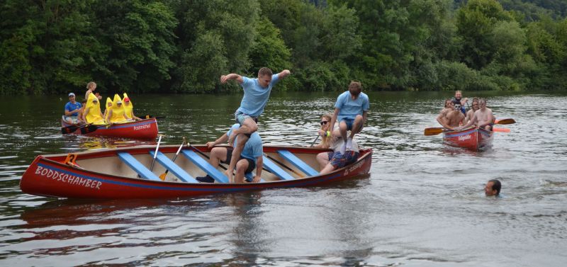 Siegermannschaft springt nach dem Ziel aus dem Boot